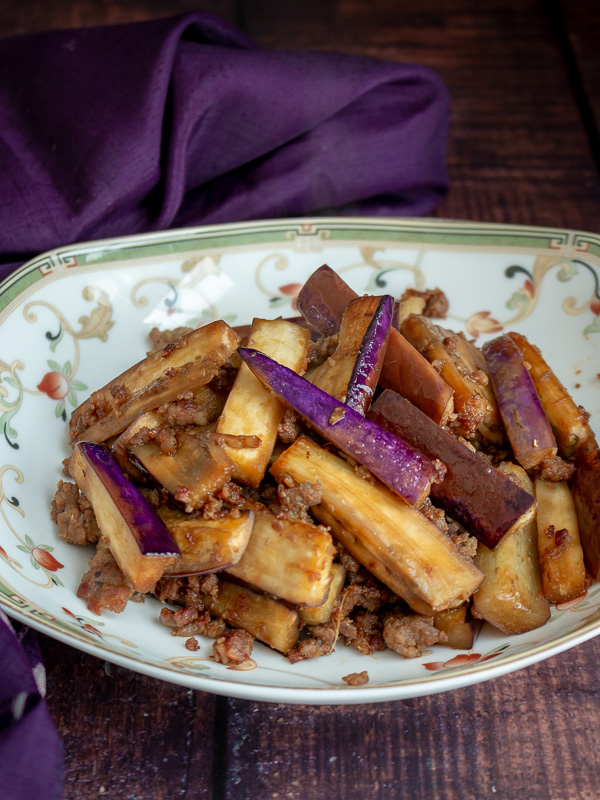 Chinese Eggplant with Spicy Pork on a white and green plate.