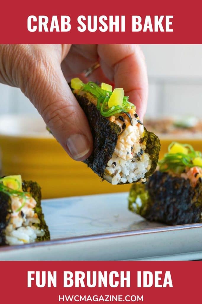 Holding a crab sushi bake prepared with all the toppings.