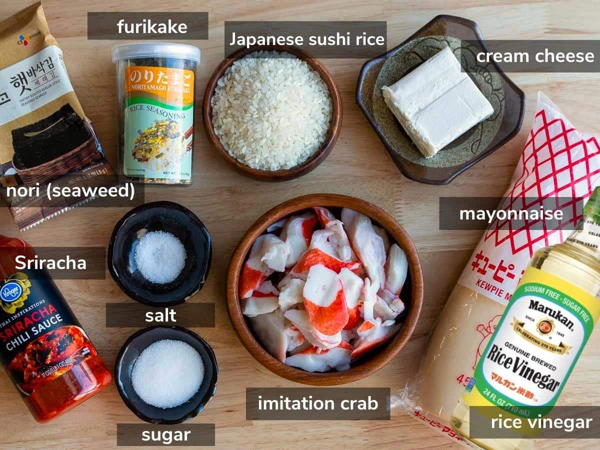 Ingredients to make a crab baked sushi laid our on a wooden table.