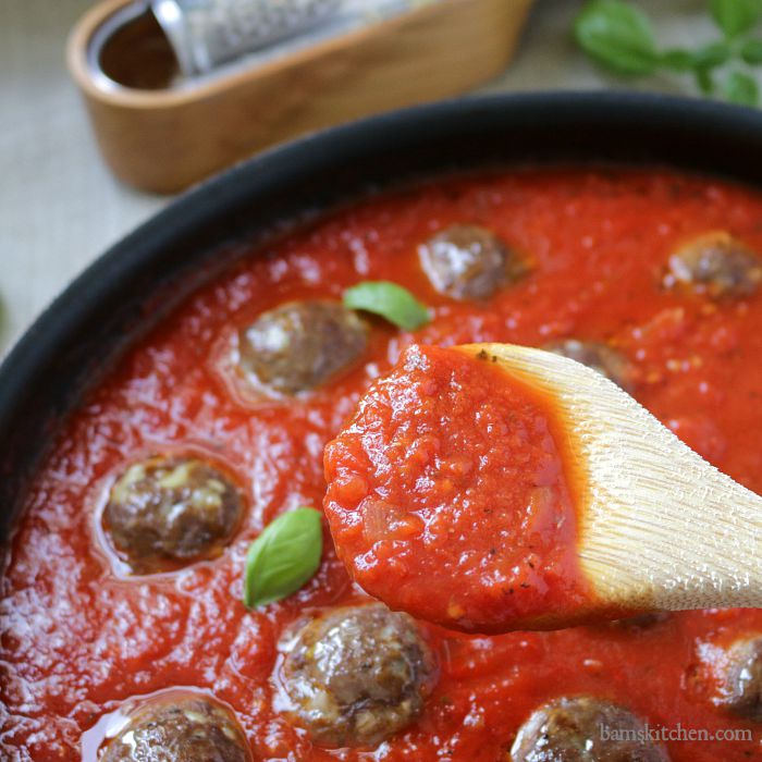 Homemade spaghetti sauce on the edge of a wooden spoon.