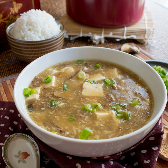 Hot and Sour Soup in white bowl served with matching Chinese soup spoons. 