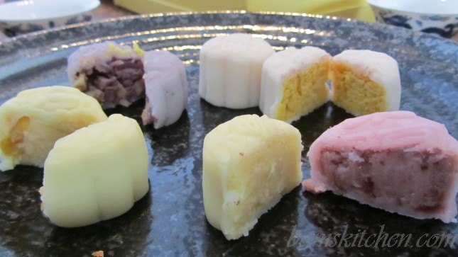 Store bought snowy moon cakes cut in half to show the different fillings.