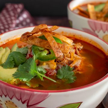 Tortilla soup topped with crispy tortillas and cilantro.