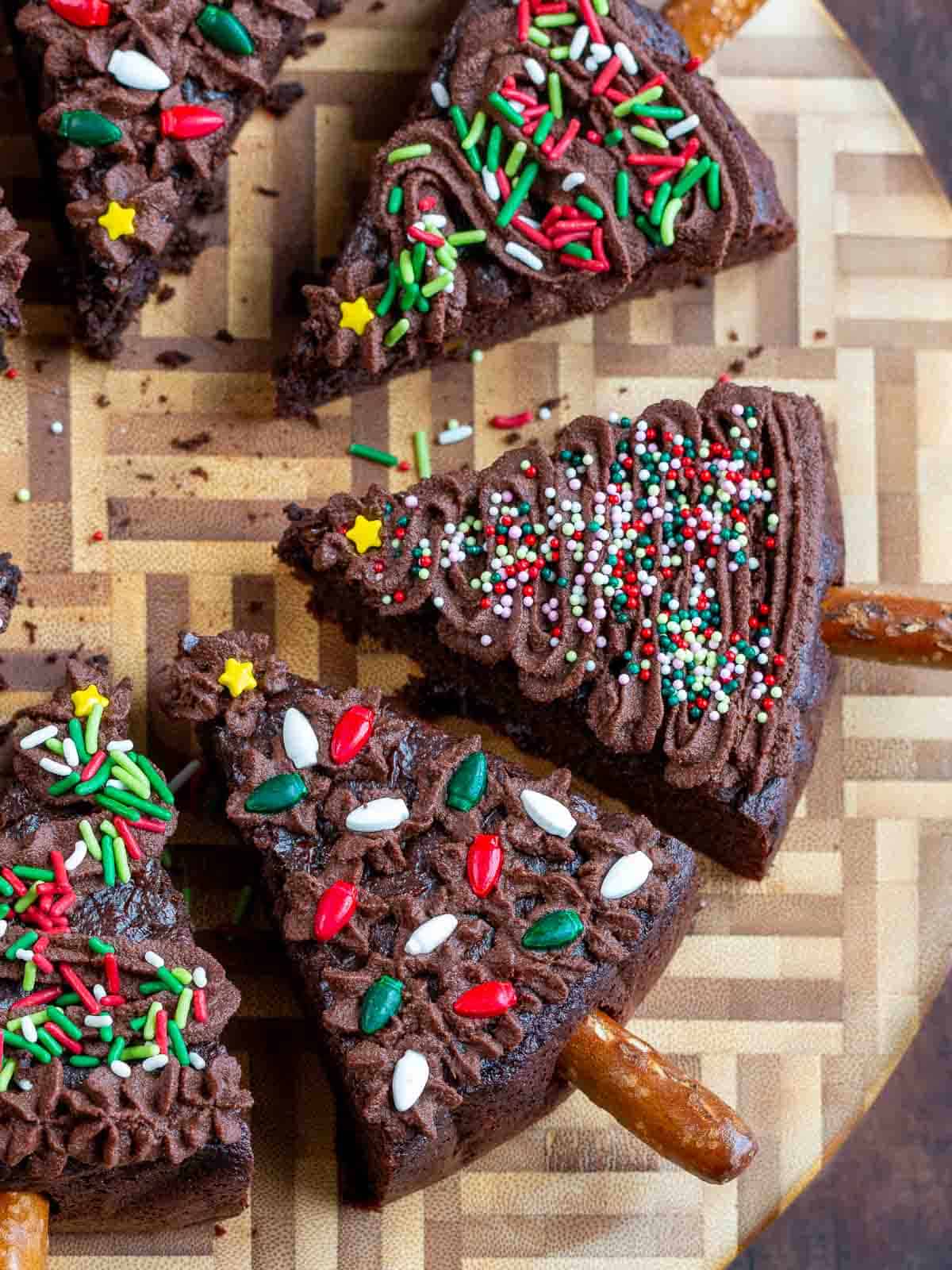 High protein brownies decorated like a xmas trees on a wooden round cutting board.