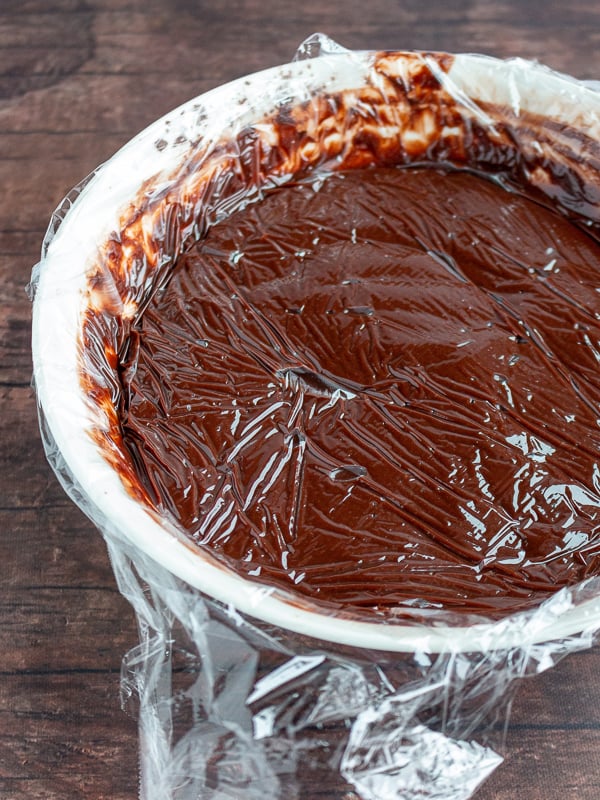 plastic wrap covering right on top of the chocolate pudding so no air touches the pudding to prevent the skin from forming.