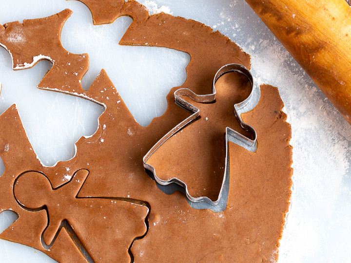 Gingerbread women getting cut out of dough.