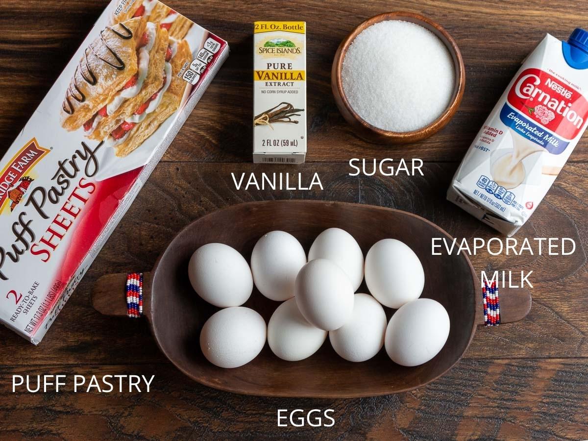 5 egg tart ingredients laid out on a wooden board.