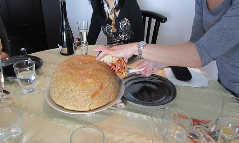 Timpano Italian Pasta Dome getting cut into at the dinner table