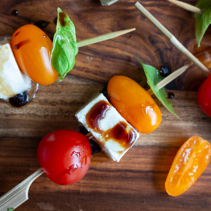 Caprese Salad on a stick drizzled with balsamic glaze.