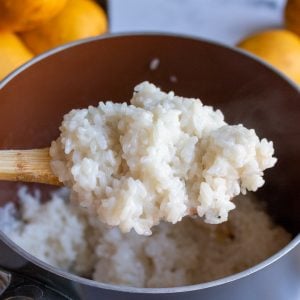 Spoonful of cooked sticky rice over the pot.