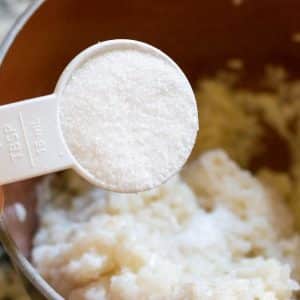 Adding sugar to the cooked sticky rice.