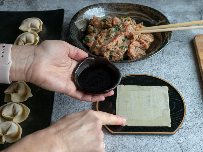 Placing a little water on the wonton with my finger.