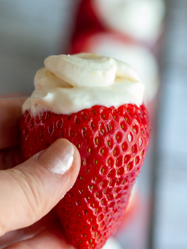 Holding a filled strawberry with an upclose macro shot of strawberry.