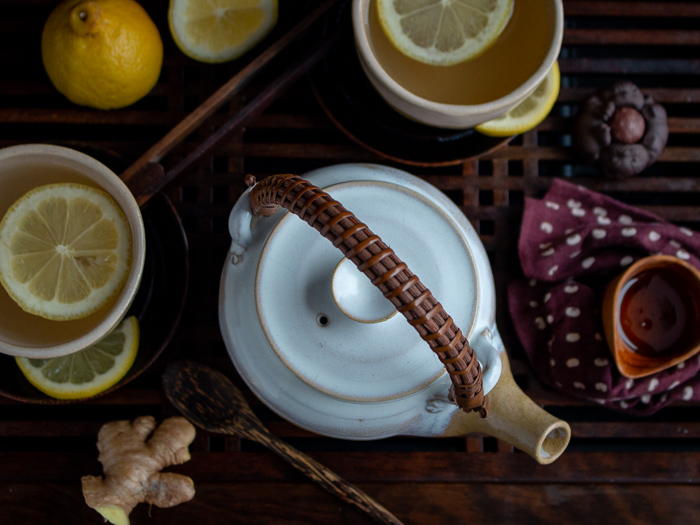 Top down shot showing the tea post and cups of tea over a Chinese wooden tea cabinet table.