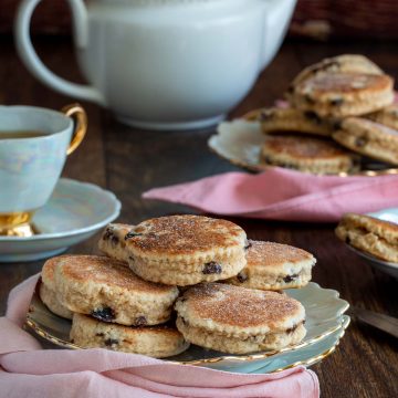 Dish of traditional welsh cakes in a pretty plate with matching tea set.