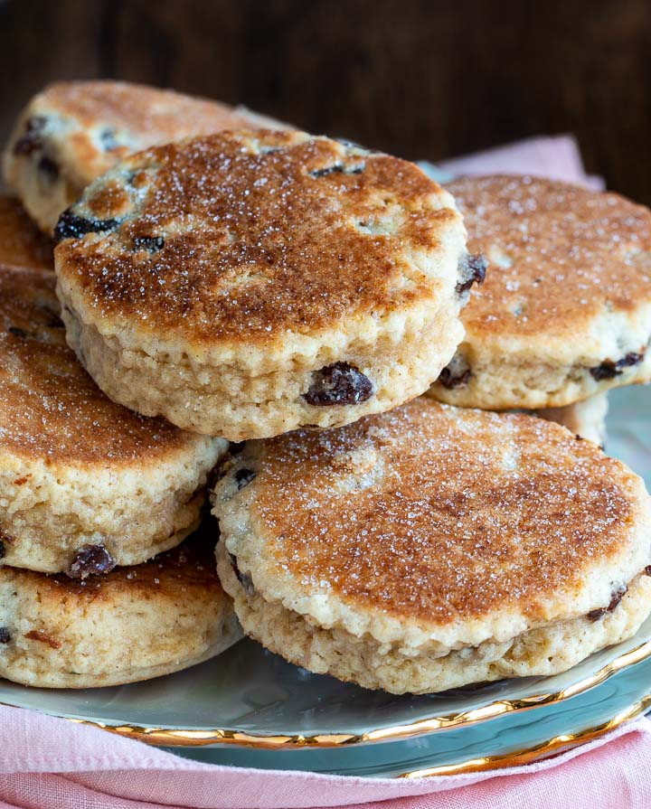 Hot off the skillet Welsh cakes stacked on a pearl white plate.