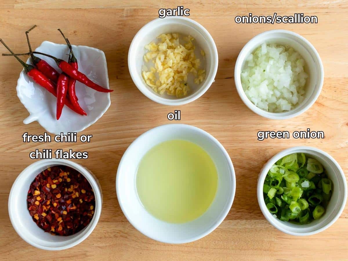 Ingredients to make chili crisp oil laid out on wooden board.