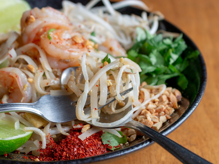 Noodles in a fork with spoon. 
