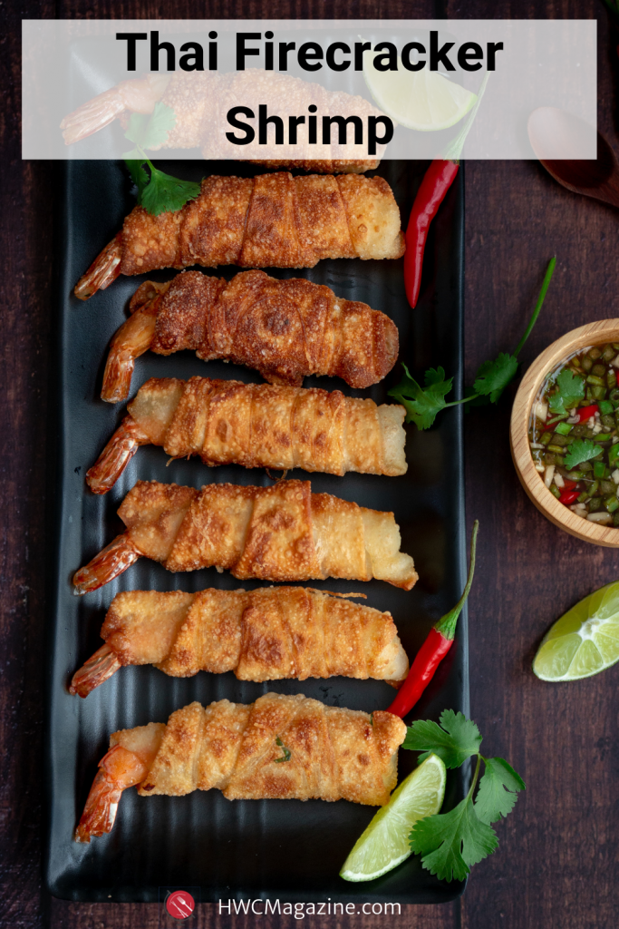 Thai Firecracker Shrimp Party Appetizer is a deliciously marinated shrimp with the tail on, bundled in a spring roll wrapper and pan fried until golden. Served with a Prik Nam Pla dipping sauce. #thai #qppetizer #shrimp #springrolls #firecracker #asian #easyrecipe #eattheworld / https://www.hwcmagazine.com