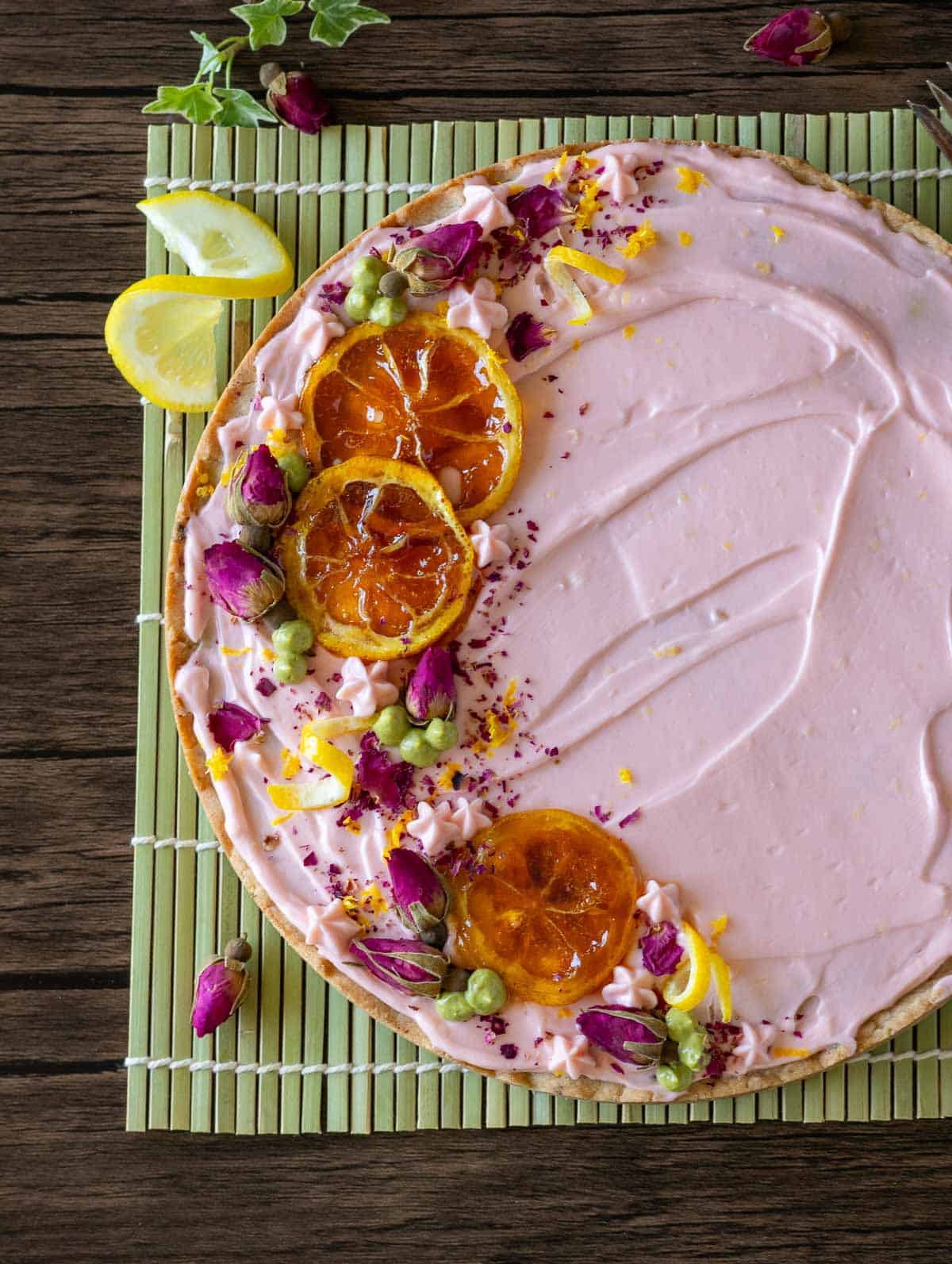 Decorated cookie cake topped with candied lemon slices, ground dried rose tea buds and lemon zest.