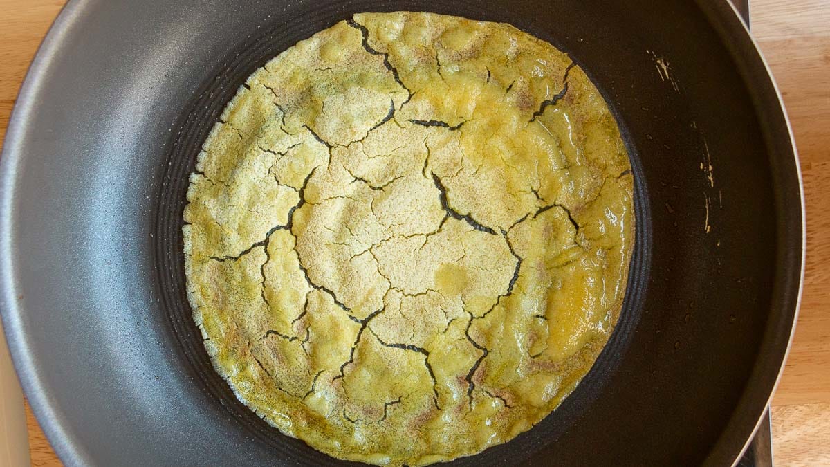 Showing an instant dosa in the pan cracking. 