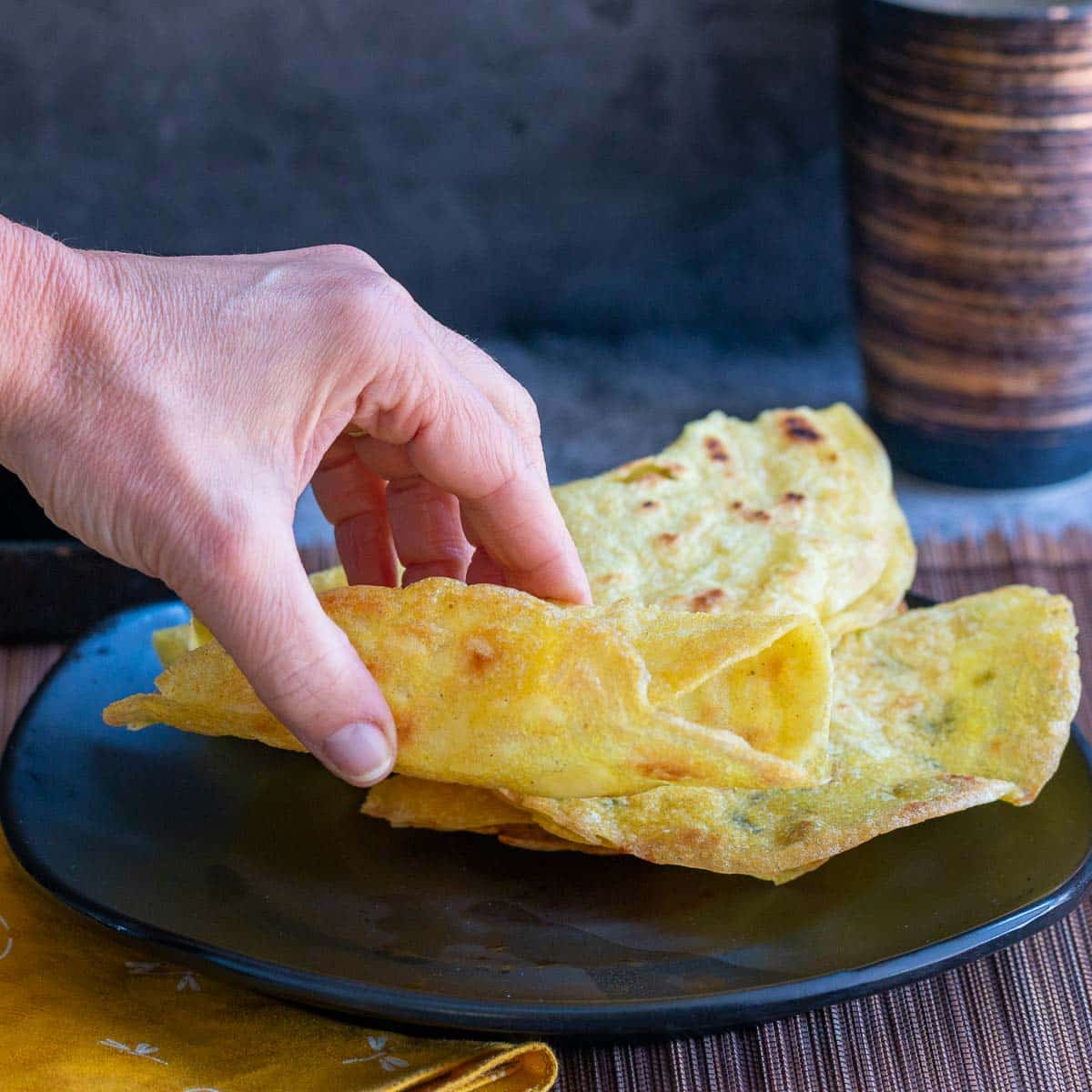 Grabbing a crispy instant dosa off a plate. 