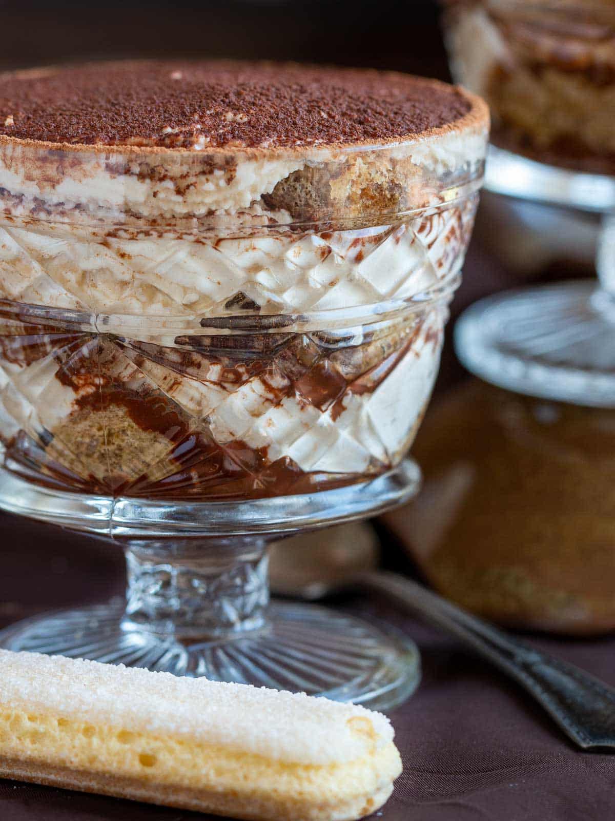 Showing all the delicious layers of the tiramisu in a glass cup. 