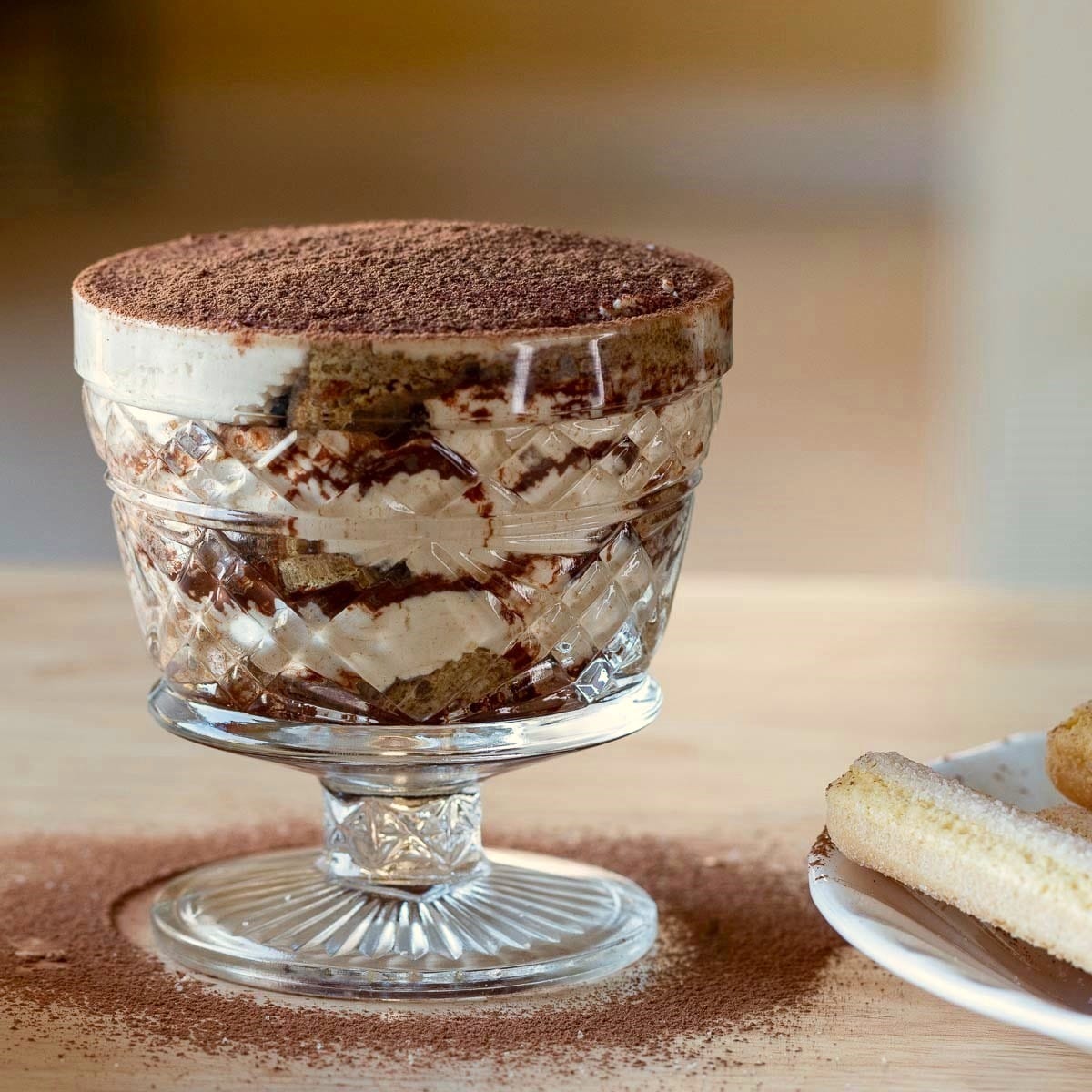 Freshly made tiramisu cup just dusted with cocoa powder.