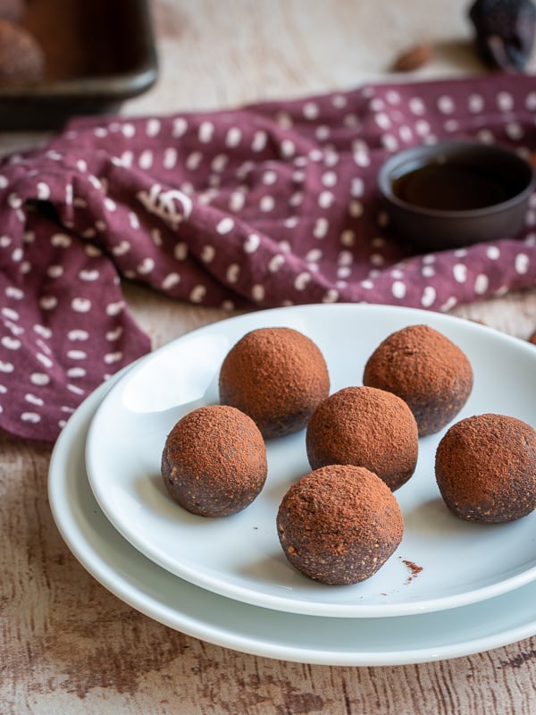 Plate of chocolate espresso fig balls with hot pu-erh tea and a brown napkin.