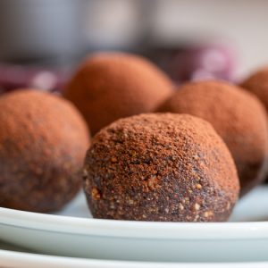 5 chocolate espresso balls on a white plate.