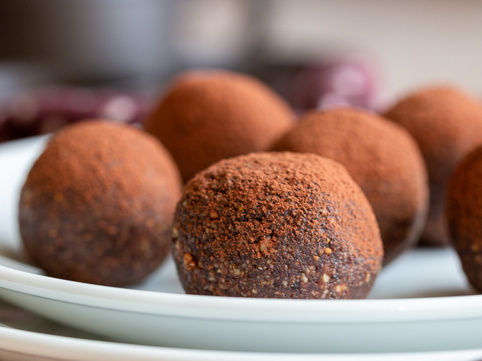 5 chocolate espresso balls on a white plate.