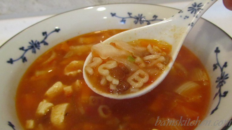 Soup spoon full of vegetable ABC soup.