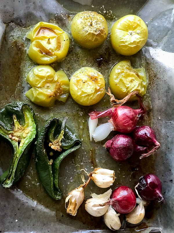 Roasted tomatillos, onions, serrano and garlic on roasting pan