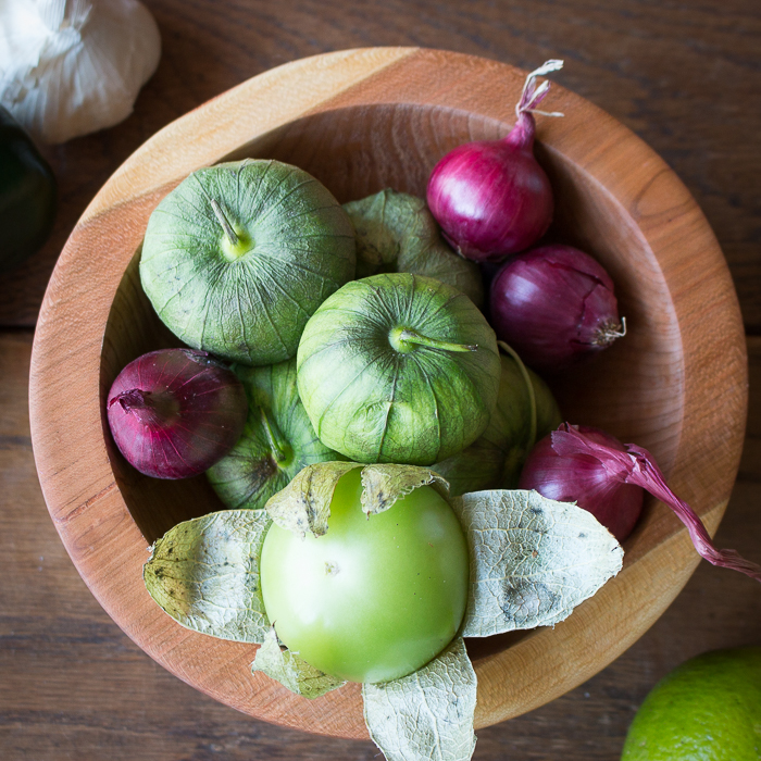 top down shot of tomatillos, onions, garlic to be roasted