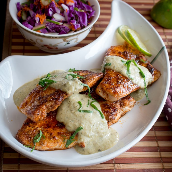 Top down photo of tomatillo salsa on chicken with a coleslaw