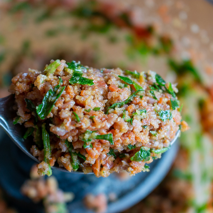 Scoop of ground chorizo with herbs and spices ready to spread on fish.