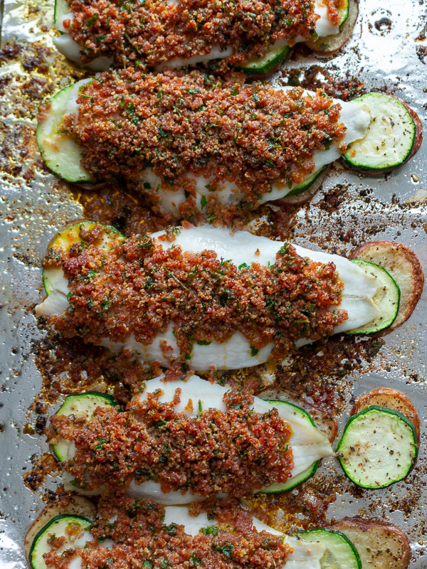 Sheet pan of cooked Baked Chorizo Crusted Fish and Potatoes looking overhead. 