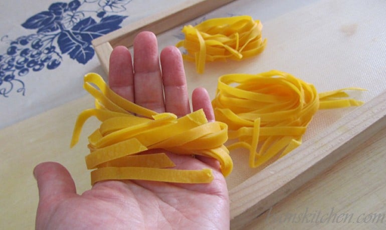 Tagliatelle noodles tossed around my hand to make a nest ready to be dried.