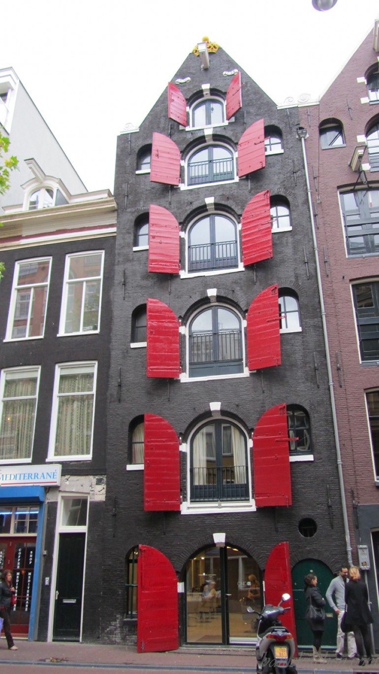 Amsterdam architecture with red shutters on the canal.