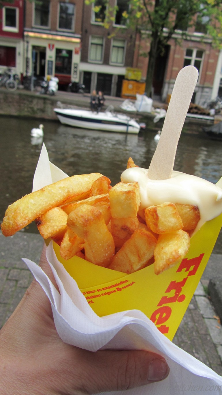 Viaamse Frites and mayo with the canal of Amsterdam in the background.