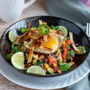 Delicious Healthy Tex Mex Breakfast Bowl garnished with lime and cilantro and crispy tortilla strips.