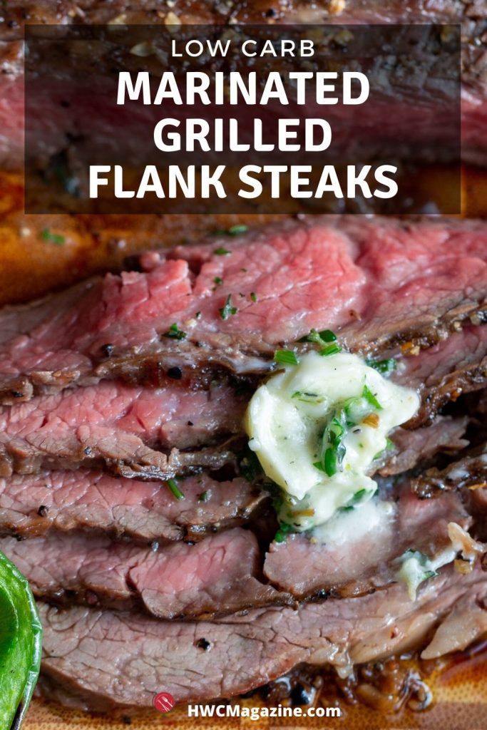 Grilled flank steak cut into thin slices on a cutting board and garnished with herb butter and fresh herbs.