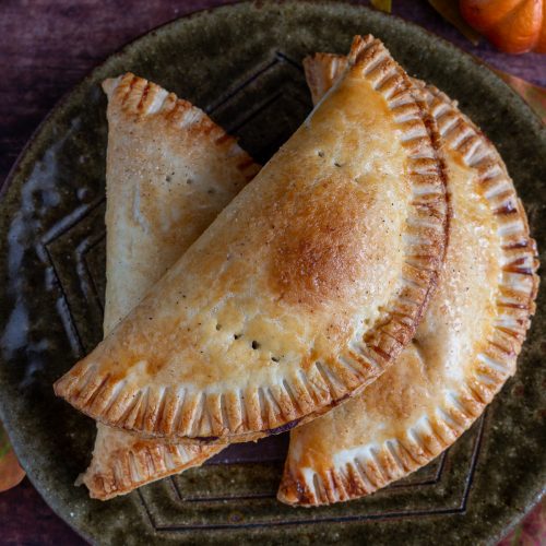 3 pumpkin hand pies on a green plate.