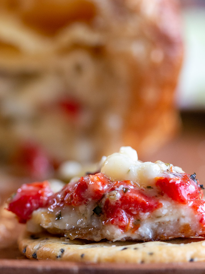 Melty brie on a cracker with olives, artichokes and roasted red peppers.