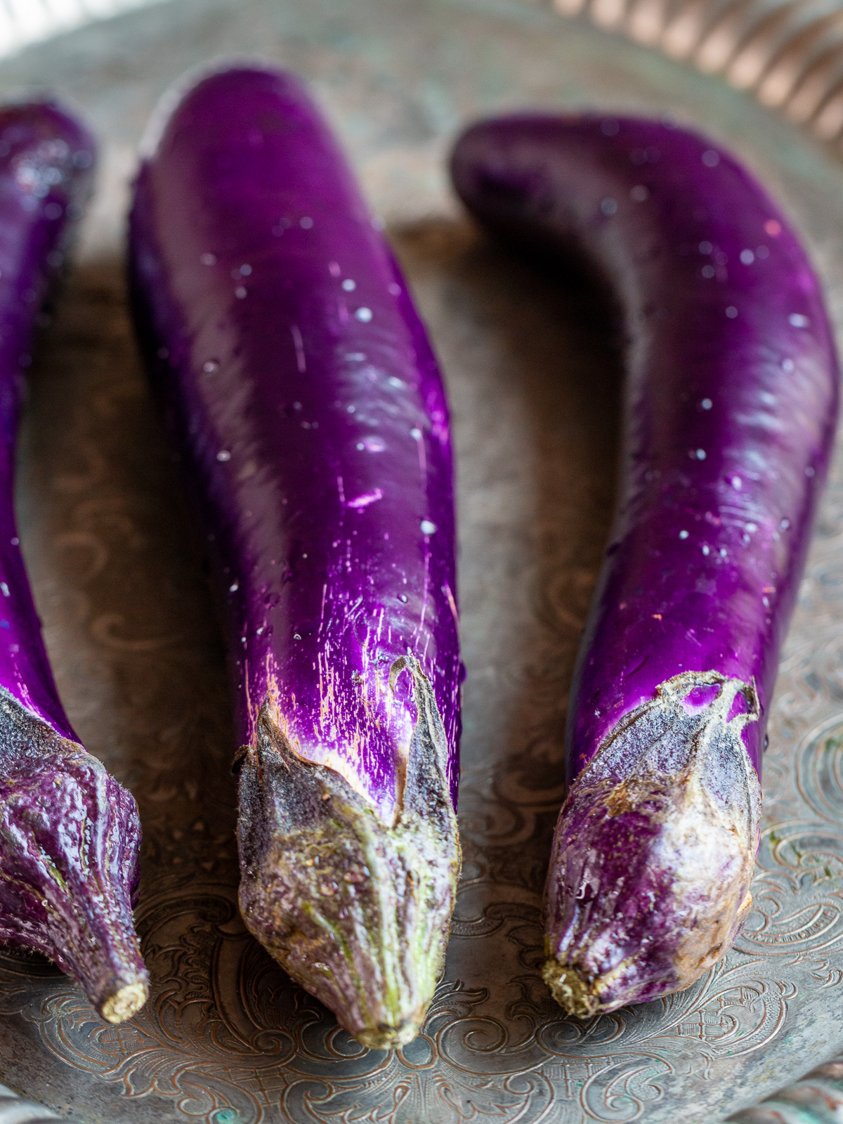 3 whole bright purple Asian eggplants.