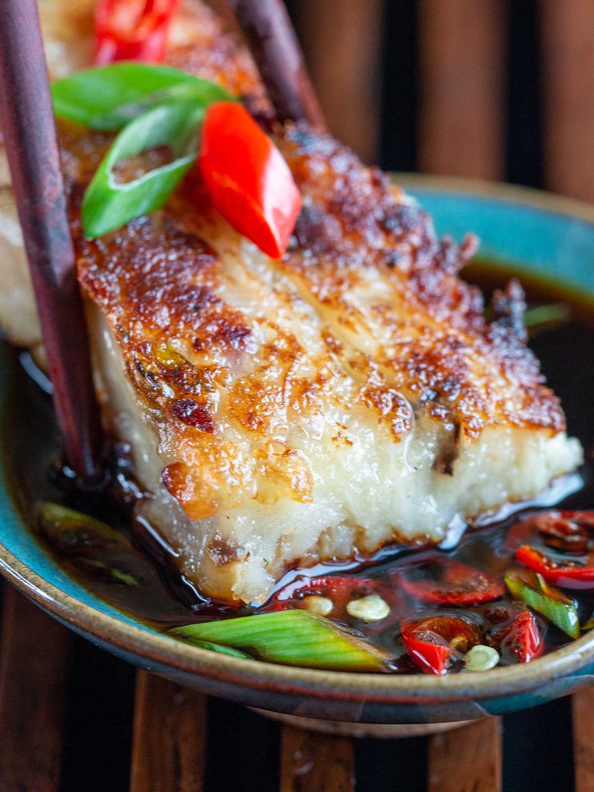 Radish cake getting dunked into the spicy dipping sauce.