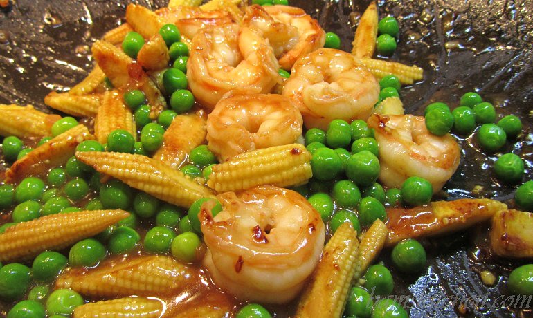 Veggies and shrimp in the wok with the delicious seasonings. Glossy and beautiful.