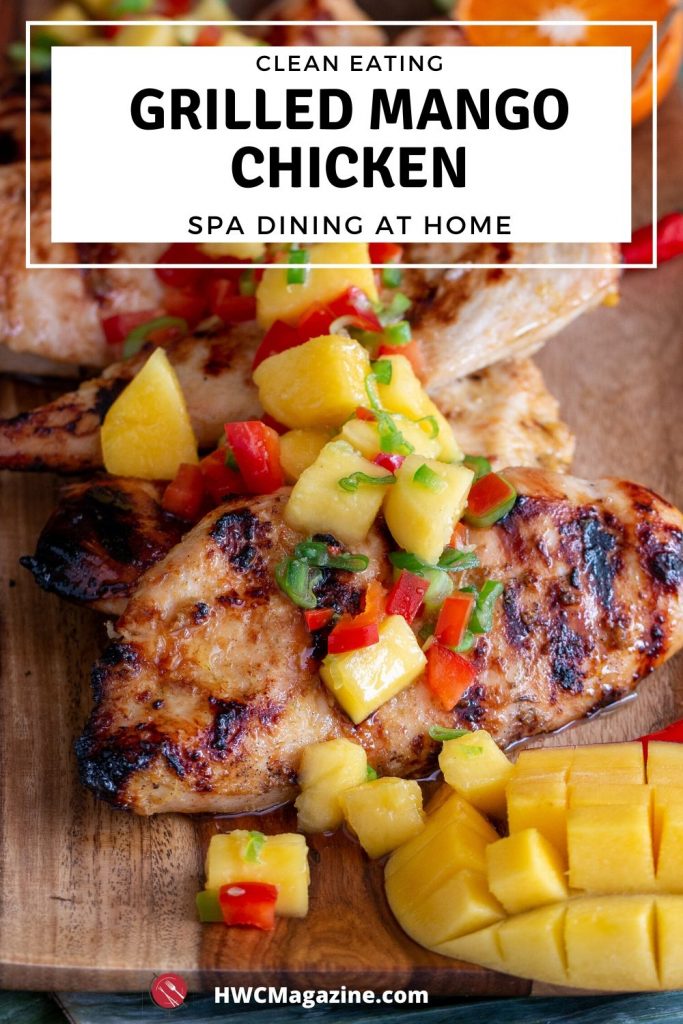 Grilled Mango chicken breasts topped with fresh mango salsa on a wooden board.
