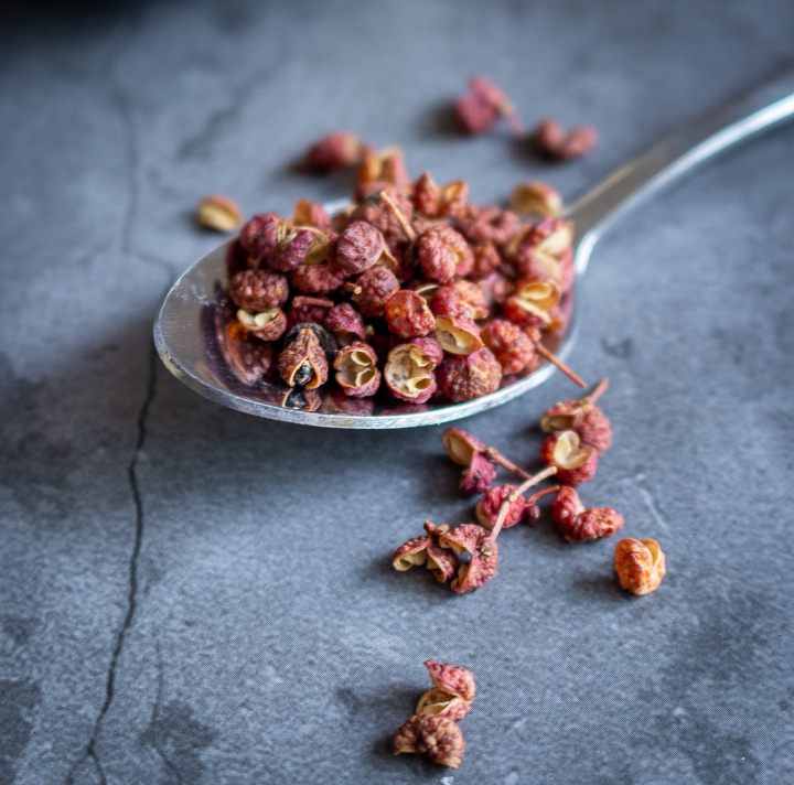 Sichuan peppercorns in a spoon.