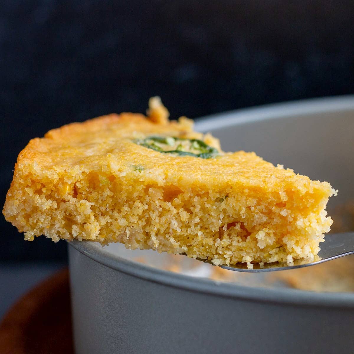 slice of air fryer cornbread taken directly from the cake pan. 